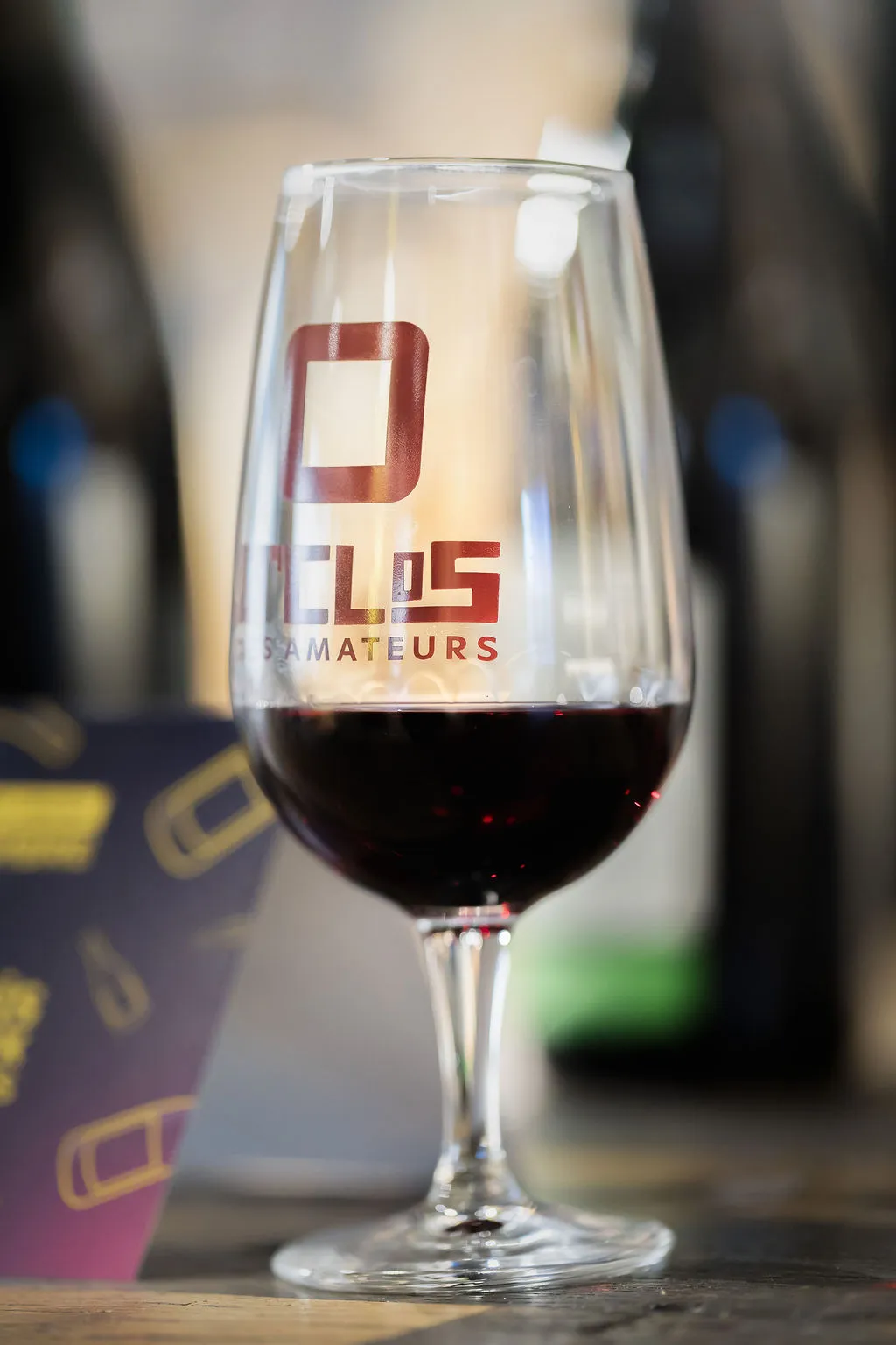 Verre de vin rouge servi au comptoir lors d'une dégustation privée